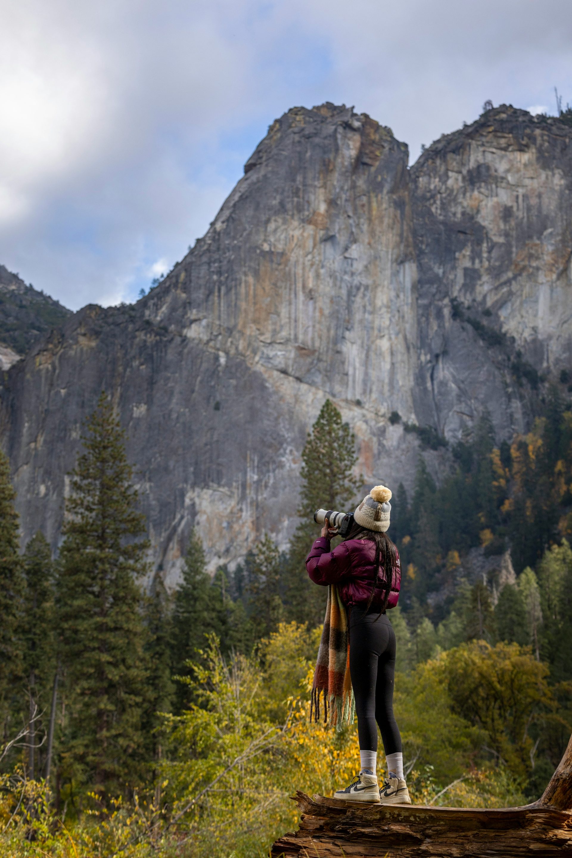 Une personne avec un sac à dos debout sur une bûche